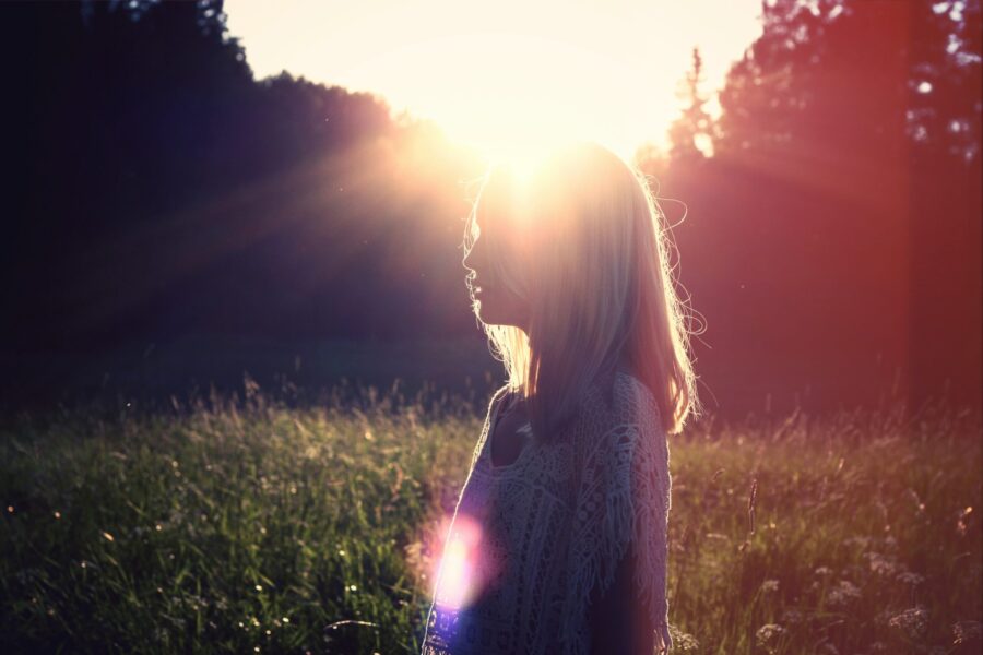 Woman standing in nature with natural sunlight representing natural sources of Vitamin D